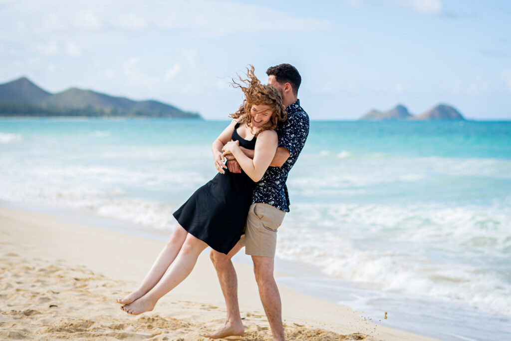 A man is holding a woman as they spin around together. This illustrates how fun a photo session can be.