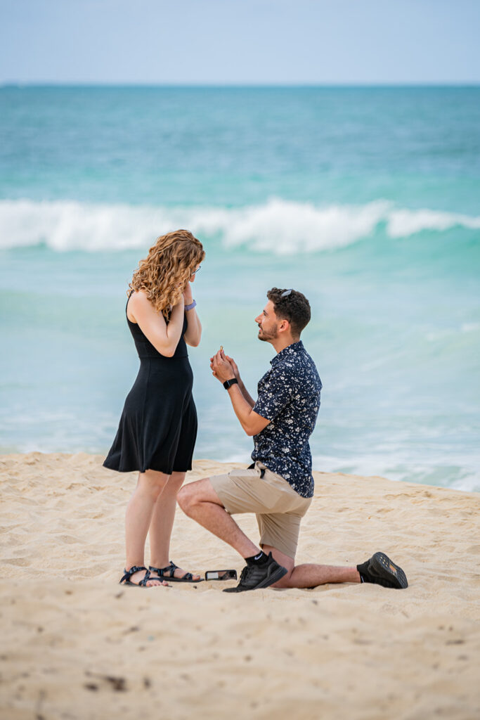 Man is on one knee proposing to a woman at their surprise proposal ohto session