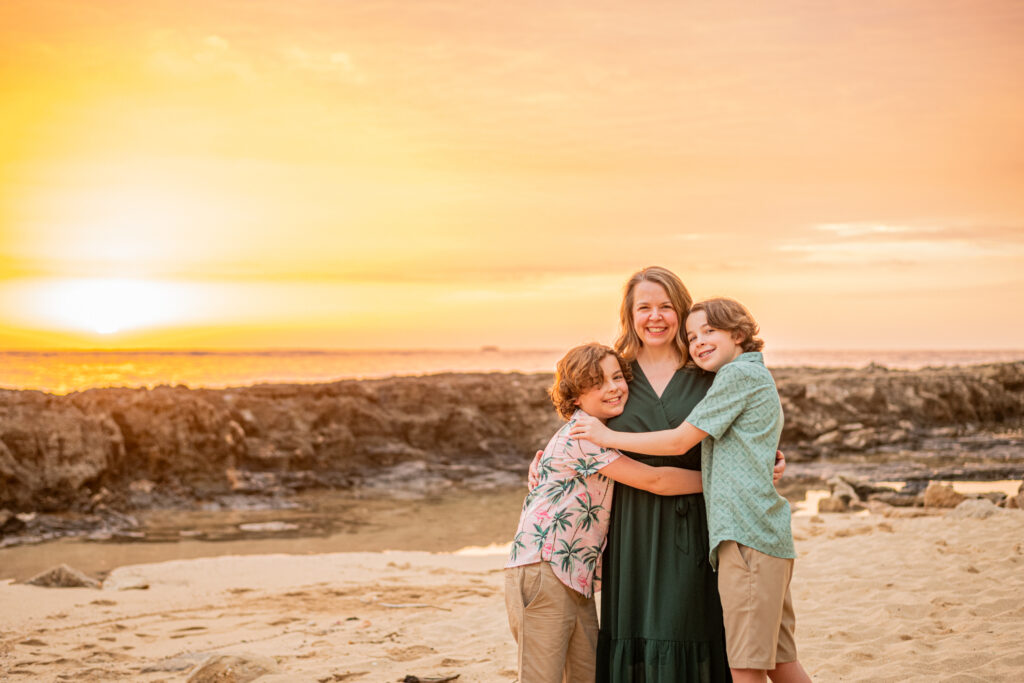 Family on the beach at sunset during their hawaii vacation photoshoot