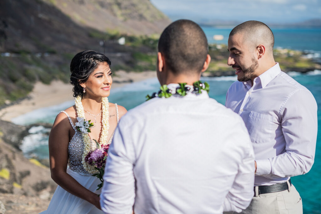 Bride and Groom look at their officiant during while they elope on a mountain in Oahu