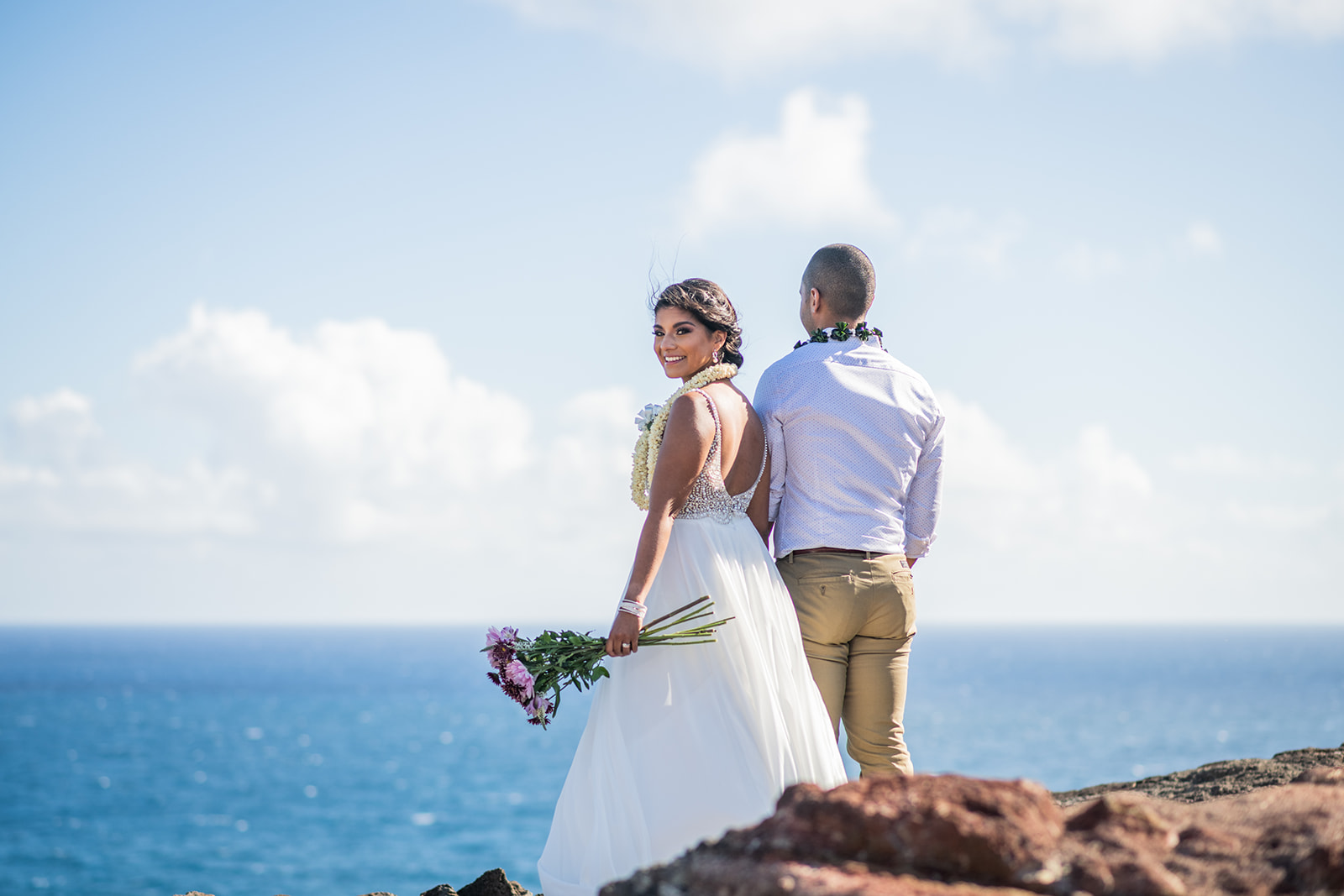 Bride and Groom are together on a cliff by the ocean during their elopement ceremony