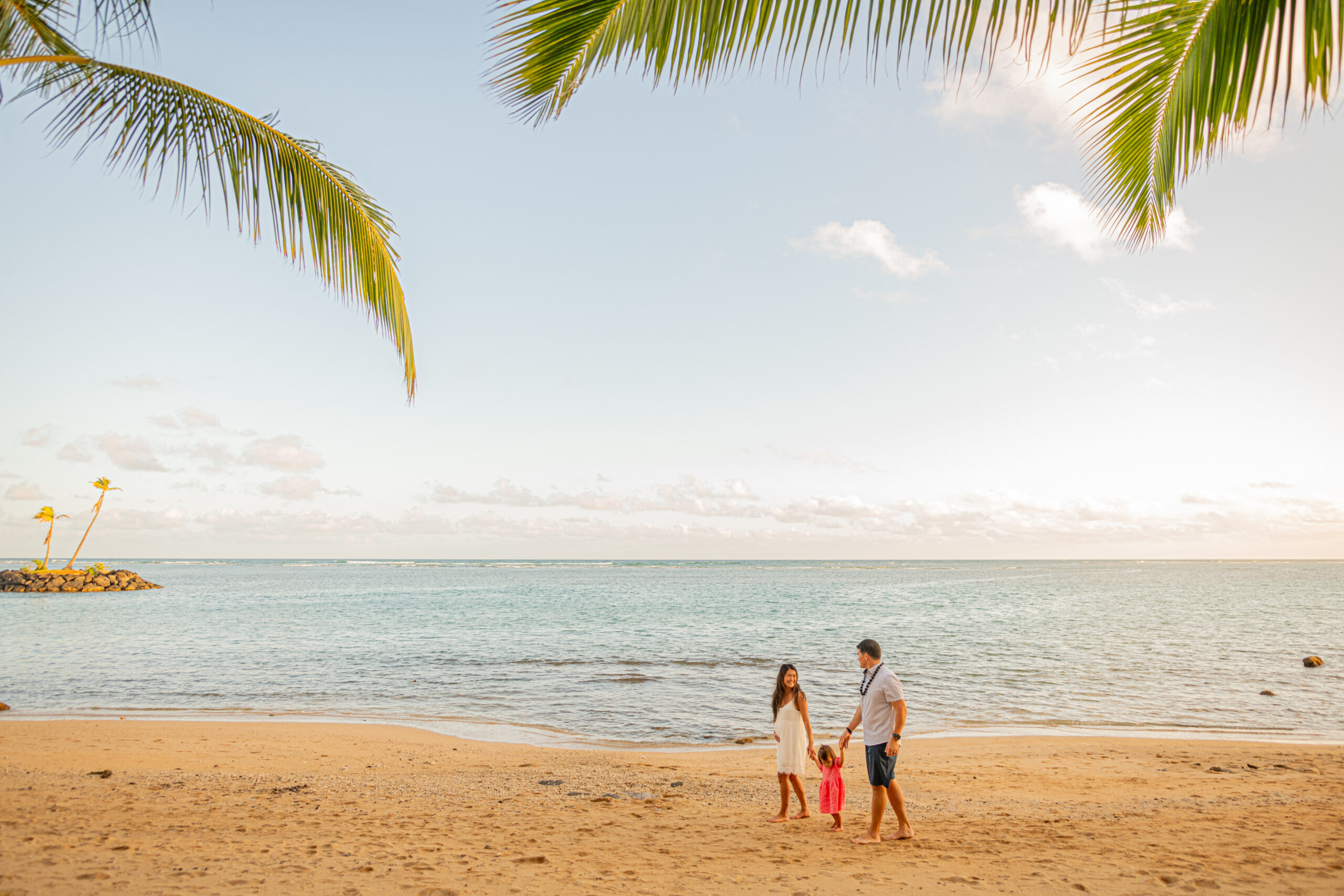 Family walking on a beach near Waikiki at sunset