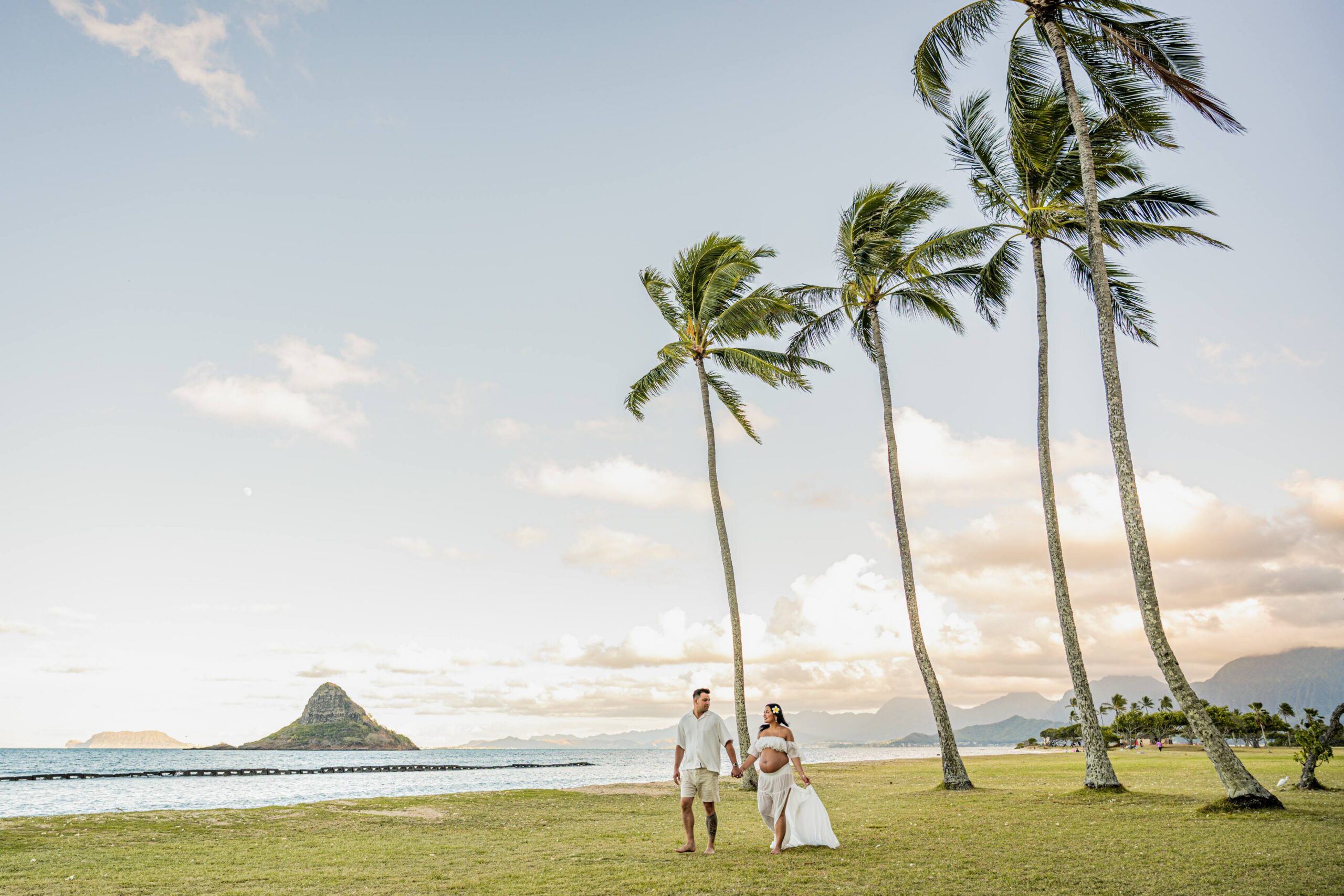 mom to be and father to be on a beach at sunset on North Shore oahu